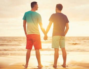 Happy gay couple watching sunset on the beach in st barths (saint barthelemy)